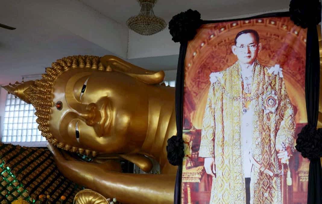 Memorial of the late King Bhumibol with life-sized image of the monarch, like this one in a temple, is seen on every street in Bangkok
